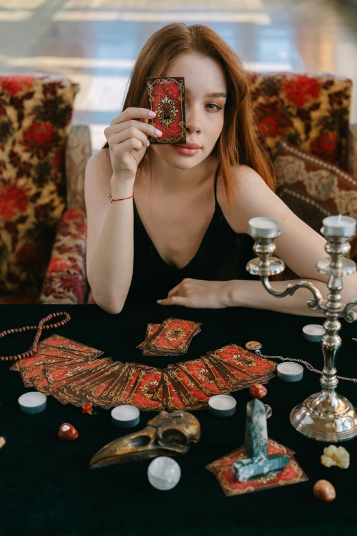 a woman sitting at a table with a phone in front of her, a cross stitch, by Julia Pishtar, trending on pexels, renaissance, major arcana palace occult, poker, set photo, an attractive