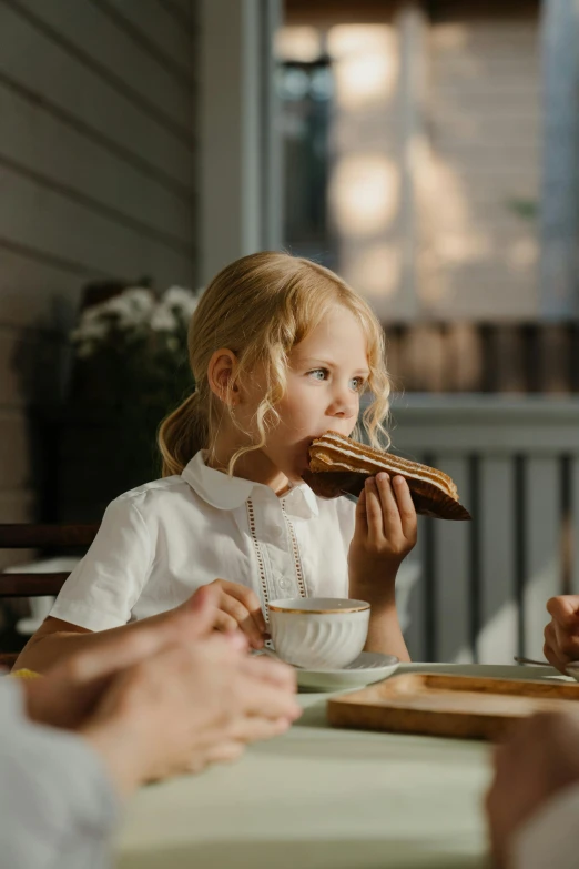 a little girl sitting at a table eating food, pexels contest winner, brown bread with sliced salo, profile image, bacon, australian