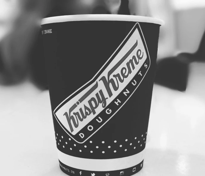 a cup of coffee sitting on top of a table, a black and white photo, by Robbie Trevino, fast food, 8 k highly detailed ❤🔥 🔥 💀 🤖 🚀, the mighty donut, paper cup