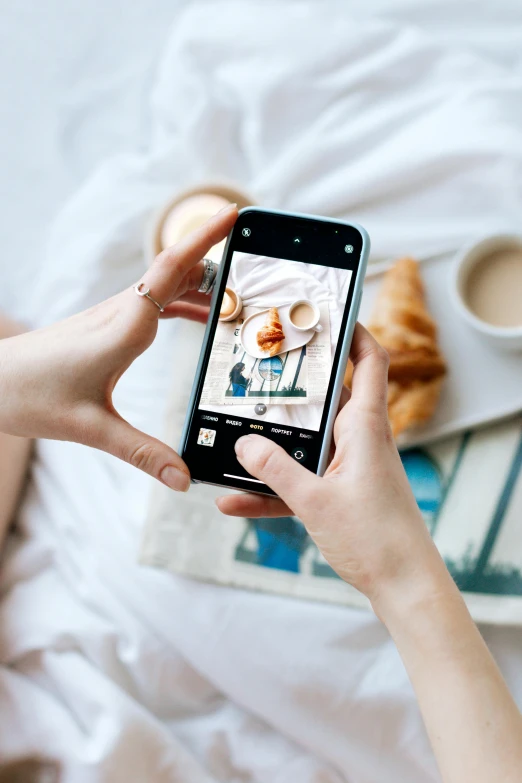 a person taking a picture of food on a bed, square, ilustration, curated collections, photography]