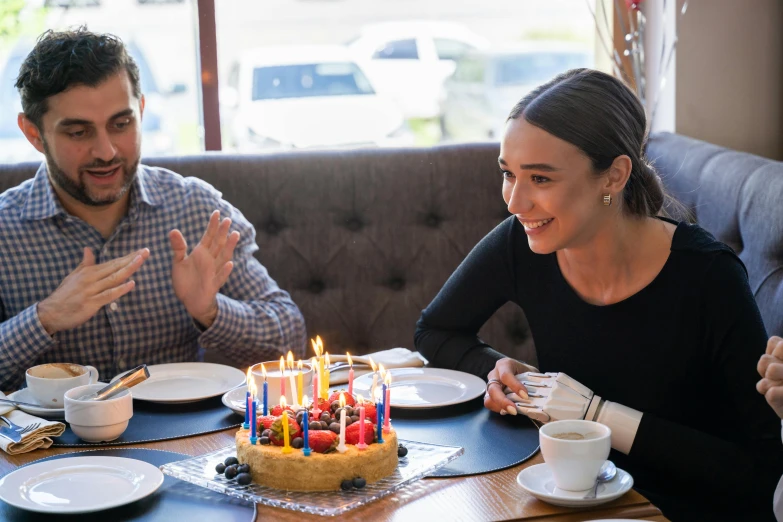 a group of people sitting around a table with a birthday cake, profile image, background image, mid morning lighting, iconic scene