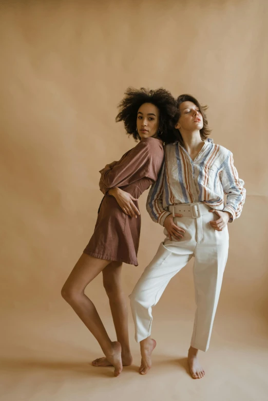 a couple of women standing next to each other, trending on pexels, renaissance, earthtone colors, choreographed, wearing a linen shirt, legs intertwined