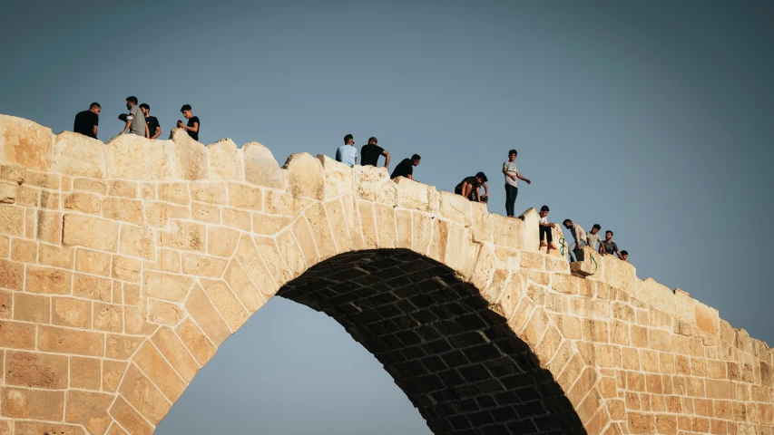 a group of people standing on top of a stone bridge, unsplash contest winner, happening, israel, sweeping arches, 15081959 21121991 01012000 4k, crisp detail