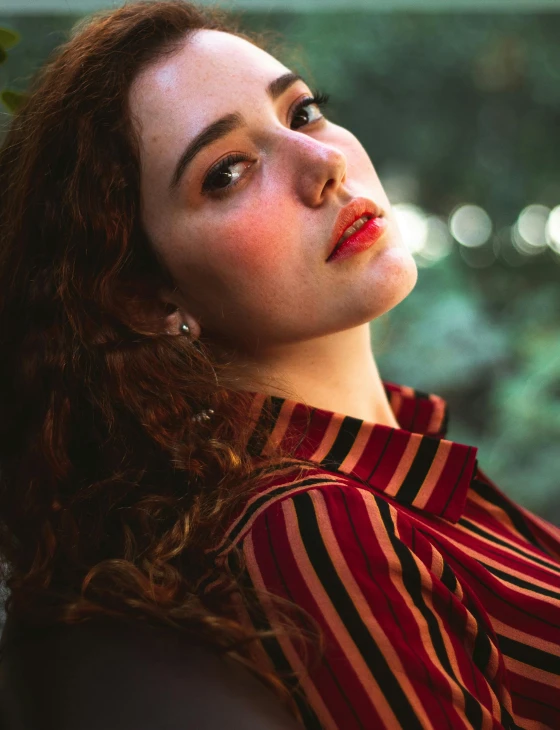 a woman with red hair wearing a striped shirt, inspired by Elsa Bleda, trending on pexels, curly haired, good lighted photo