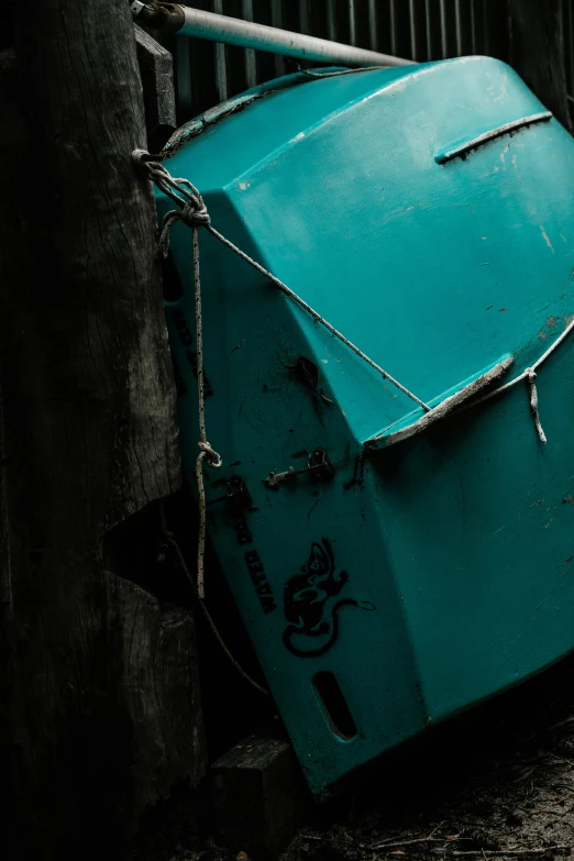 a blue refrigerator sitting on the side of a building, inspired by Elsa Bleda, unsplash, graffiti, boat, dark teal, debris, macro image