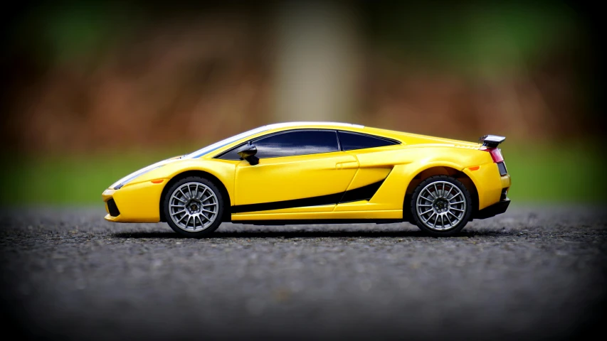 a yellow toy car sitting on top of a parking lot, pexels contest winner, lamborghini, small gadget, rally car, vibrating