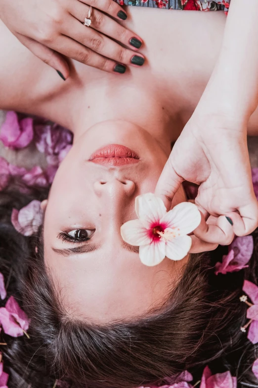 a woman laying on top of a bed of flowers, trending on unsplash, aestheticism, oriental face, bali, dry skin, plumeria