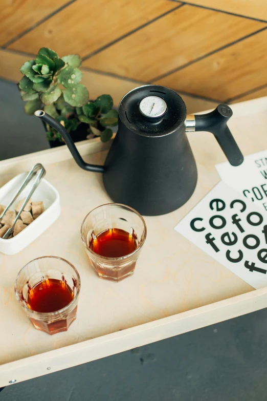 a tray that has some drinks on it, celebration of coffee products, kettle, pair of keycards on table, thumbnail