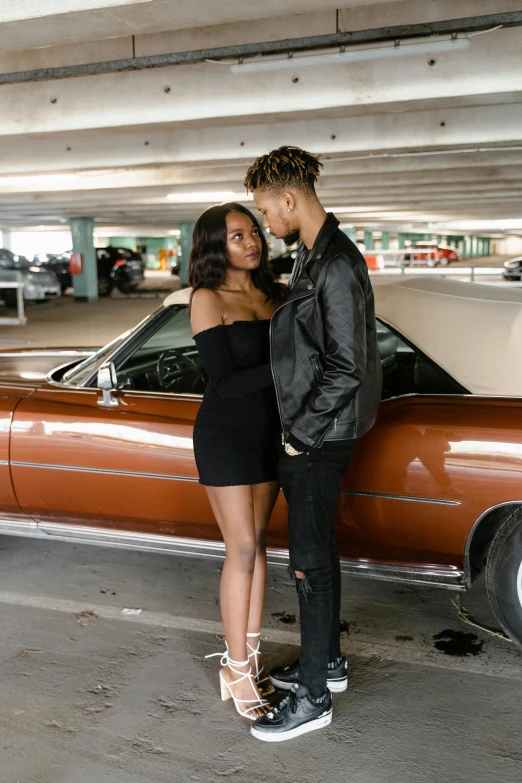 a man and a woman standing next to a car, an album cover, trending on pexels, black teenage girl, black and brown, 5 0 0 px models, hollywood standard