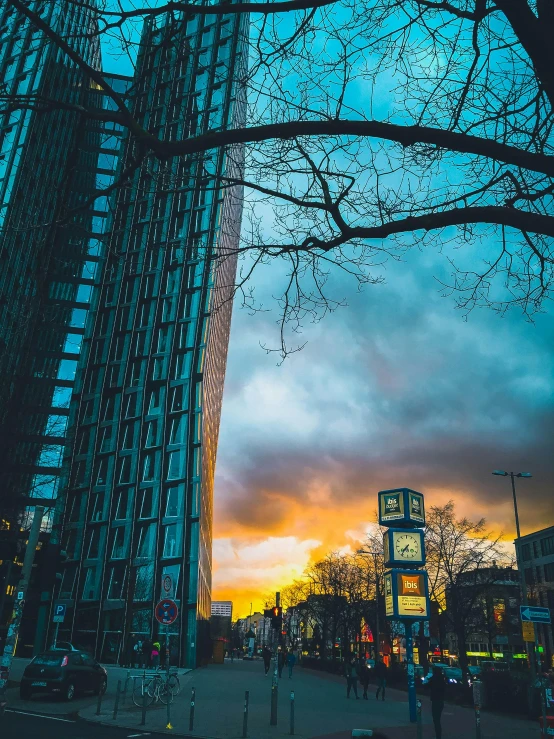 a couple of tall buildings sitting next to each other, by Sebastian Spreng, pexels contest winner, colours of the sunset, hannover, low quality photo, multiple stories