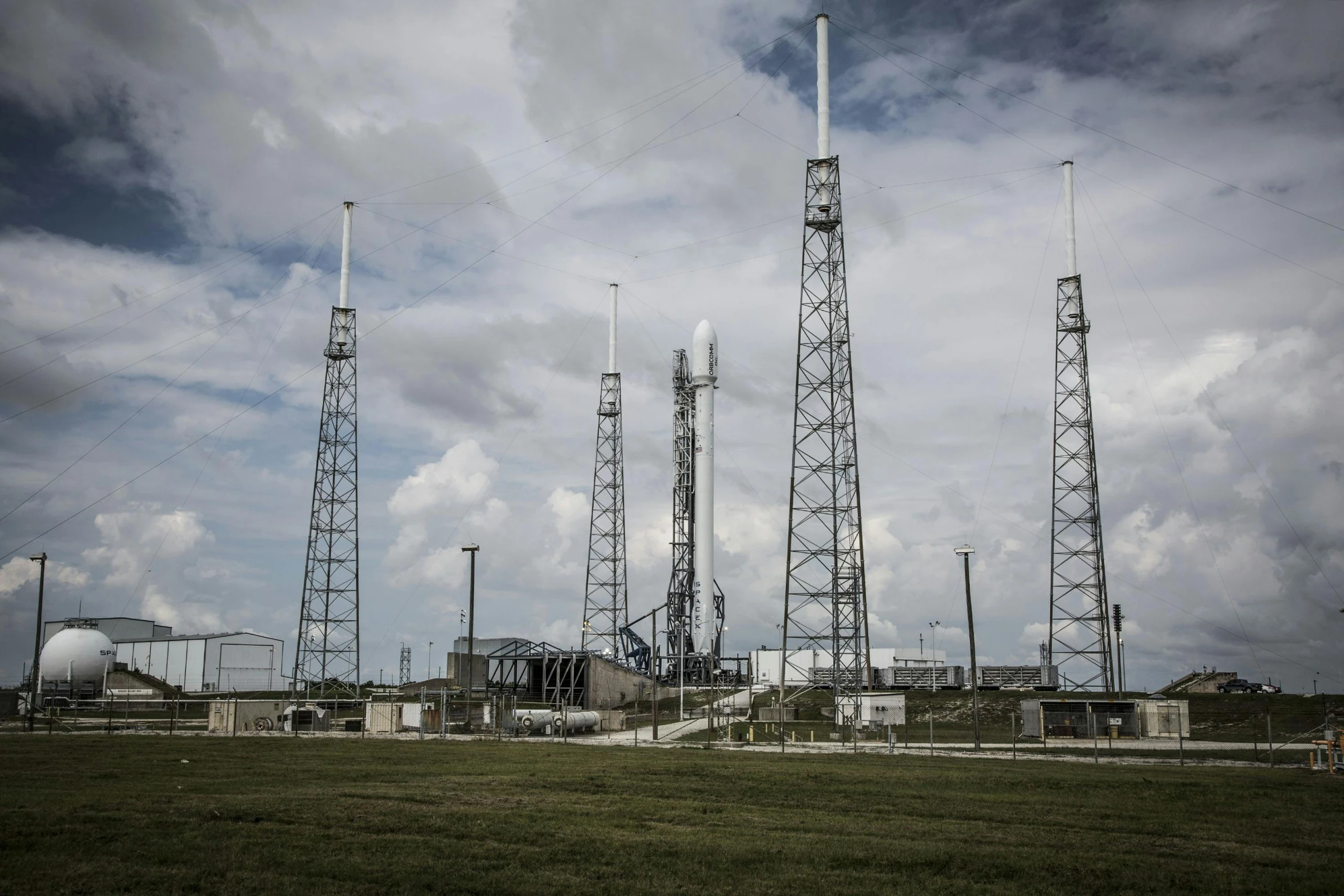 a group of radio towers sitting on top of a lush green field, spacex, full body image, richard garriott, spaceship being repaired