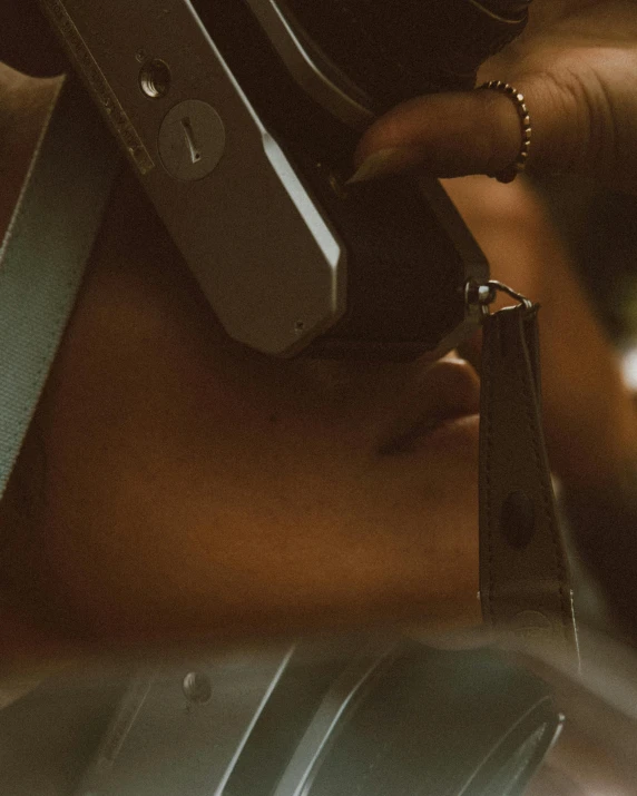 a close up of a person holding a camera, inspired by Nan Goldin, afrofuturism, headset, desaturated, low quality photo, girl making a phone call