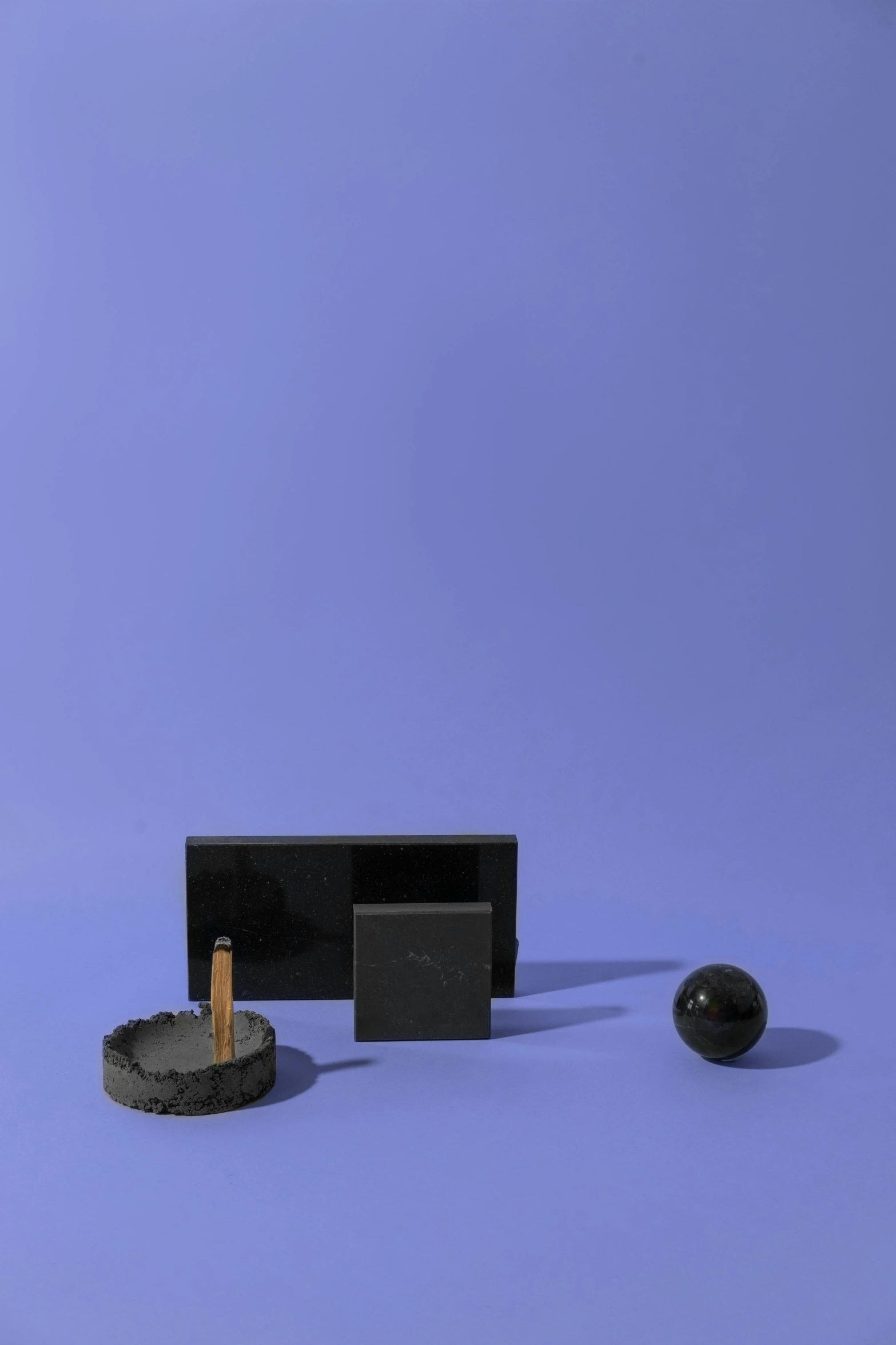 a black object sitting on top of a blue surface, various items, desks, ashford black marble, medium: black pencil