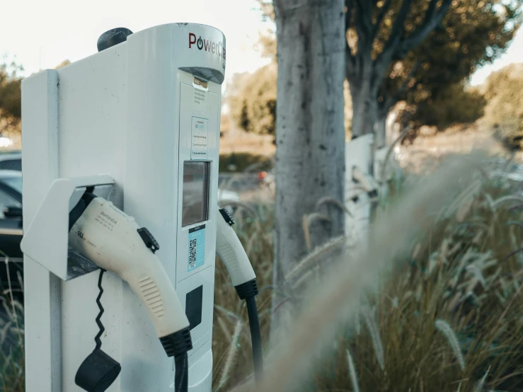 an electric charger sitting on the side of a road, by Carey Morris, pexels contest winner, off-white plated armor, a park, southern california, planted charge