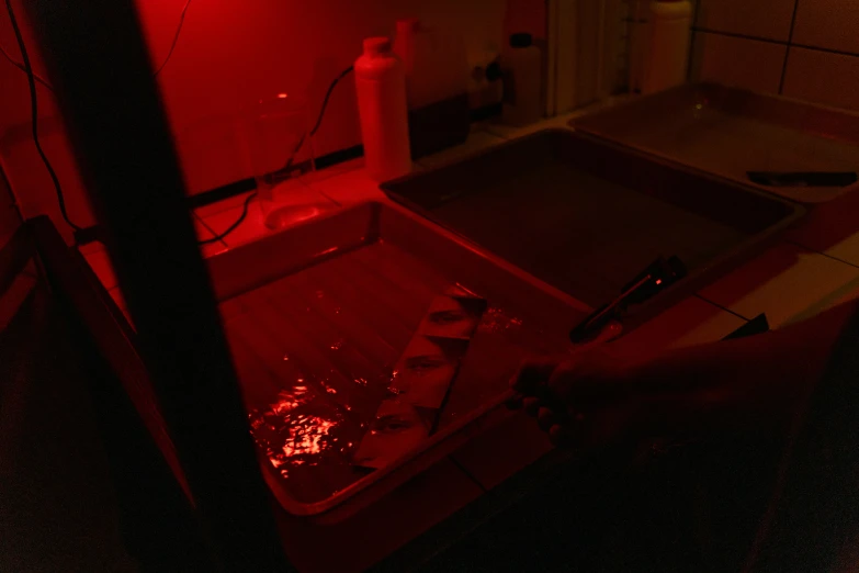 a red light illuminates the interior of a kitchen, a silk screen, process art, dna experiment, bleeding in the bath, low quality photo, hydroponic farms