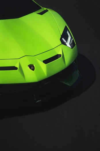 a green sports car sitting on top of a black floor