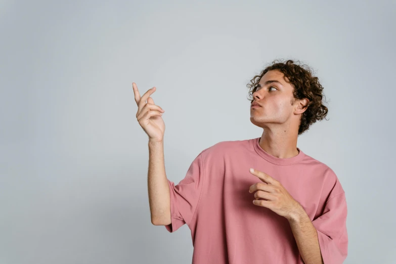 a man in a pink shirt pointing at something, trending on pexels, 18 years old, non binary model, hovering indecision, ilustration