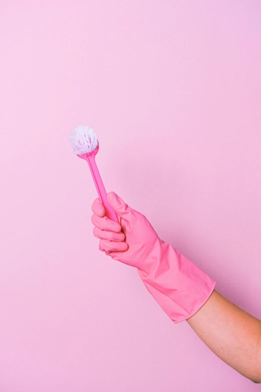 a person in pink gloves holding a pink toothbrush, holding a wand, 2019 trending photo, sweeping, centered design