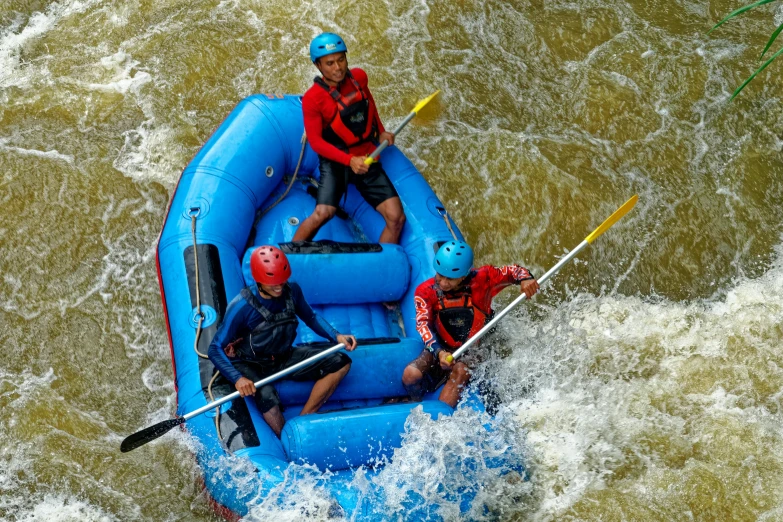 a group of people riding on top of a blue raft, by James Warhola, pexels contest winner, rapids, tan, helmet view, teaching