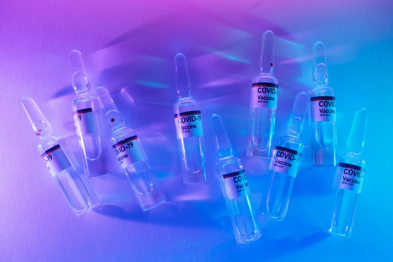 a group of vials sitting on top of a table, an album cover, inspired by An Gyeon, trending on pexels, purple and blue neons, syringe, textured base ; product photos, medical labels