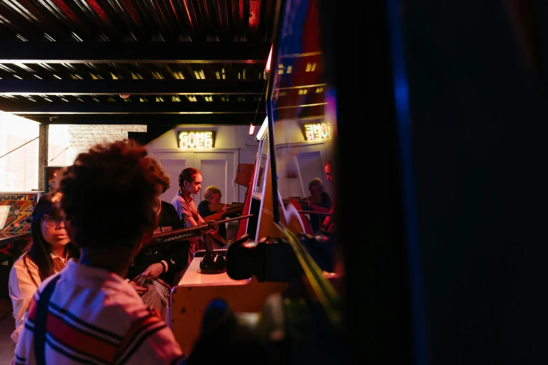 a group of people that are standing in a room, music being played, inside mirror, inside a bar, gameshow