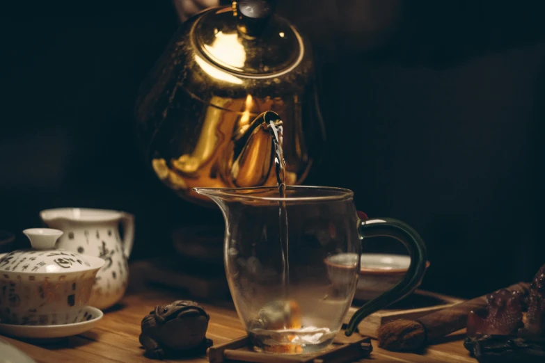 a person pouring tea into a glass cup, a still life, pexels contest winner, shiny gold, kettle, avatar image, brown