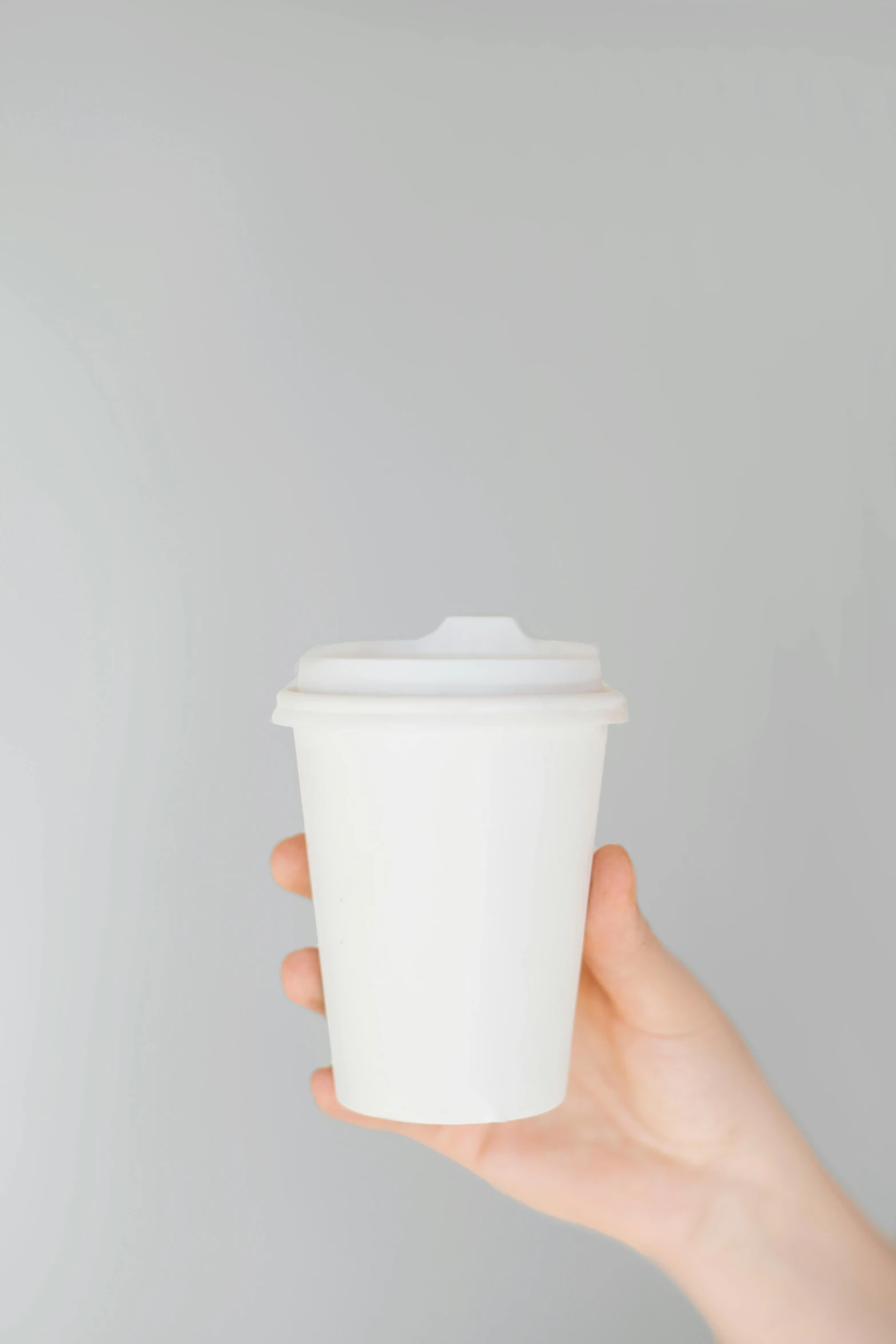 a person holding a cup of coffee in their hand, by Nicolette Macnamara, trending on unsplash, minimalism, white plastic, 2995599206, made of lab tissue, paper cup