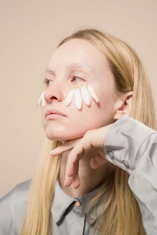 a woman with white paint on her face, an album cover, by Anna Füssli, aestheticism, giant white daisy flower face, with a white complexion, hand on cheek, silicone skin