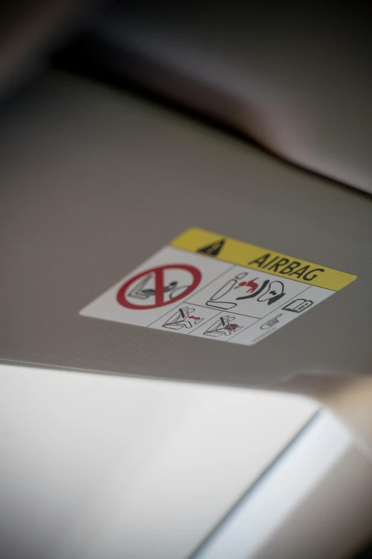 a close up of a laptop with a sticker on it, by Nina Hamnett, unsplash, inside airplane, traffic signs, square, high quality photo