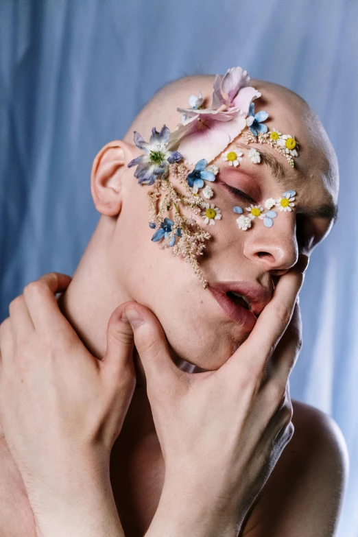 a close up of a person with flowers on their face, by artist, aestheticism, androgynous male, hairless, skincare, very artistic pose