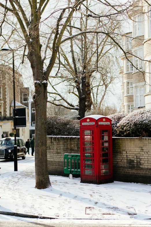 a red telephone booth sitting on the side of a road, by Andrew Bell, private press, winter, square, kings row in the background, 2023 4k