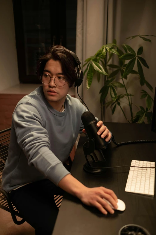 a man sitting at a desk in front of a computer, an album cover, by Jang Seung-eop, pexels, holding microphone, gaming, pokimane, no - text no - logo