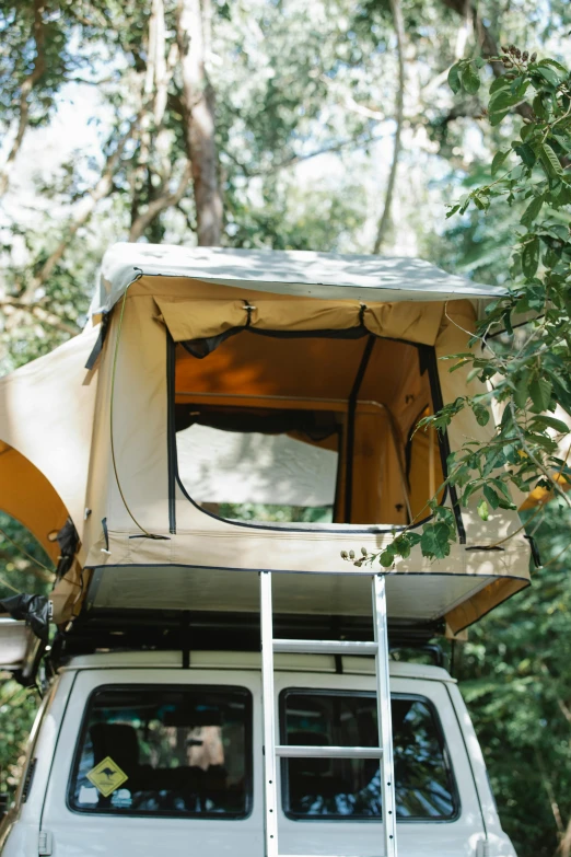 a van parked in the woods with a tent on top of it, high-body detail, yellow, australian, window open