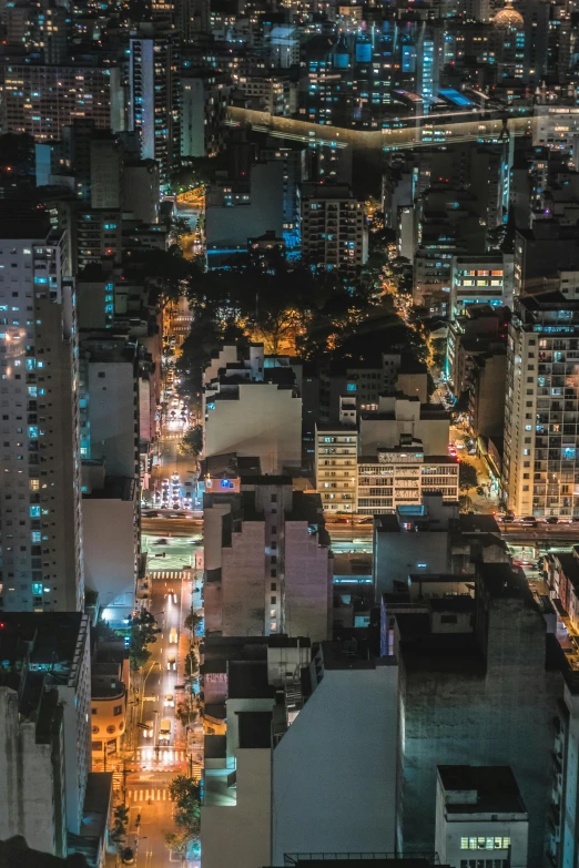 an aerial view of a city at night, by Felipe Seade, happening, outdoors tropical cityscape, full building, nightlife, buildings