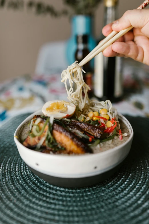 a person holding chopsticks over a bowl of food, square, vine, glazed, alana fletcher