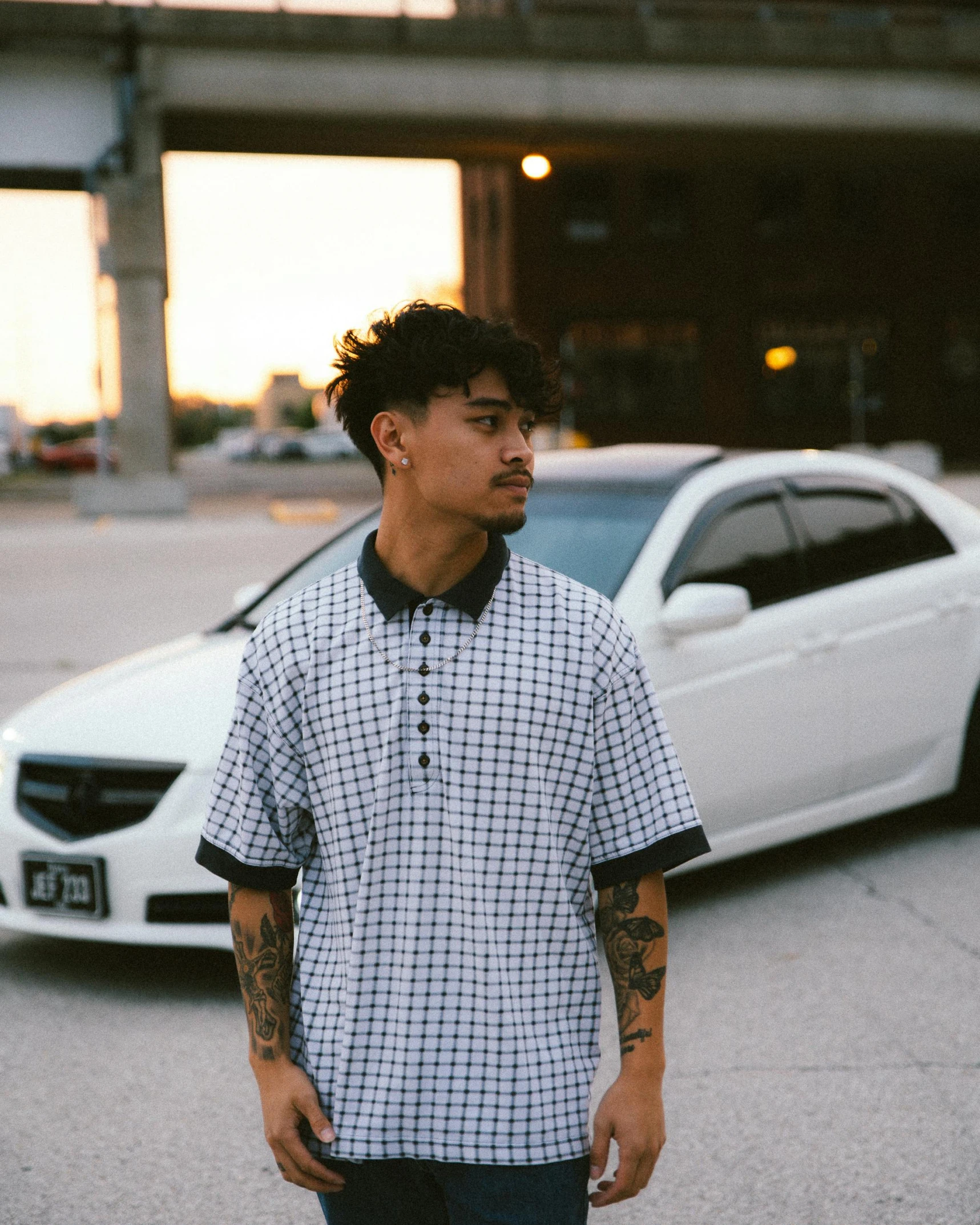 a man standing in front of a white car, inspired by Eddie Mendoza, unsplash, non binary model, wearing polo shirt, checkered spiked hair, bao pham