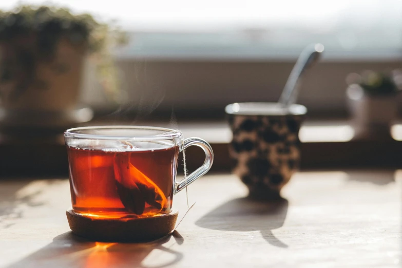 a cup of tea sitting on top of a table, pexels contest winner, arabesque, with backdrop of natural light, profile image, thumbnail