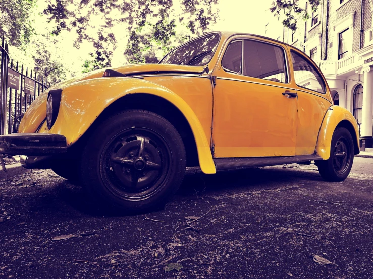 a yellow car parked on the side of the road, pexels contest winner, photorealism, scarab, retro coloring, kreuzberg, low quality photo