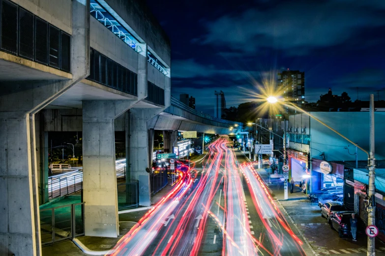 a city street filled with lots of traffic at night, by Alejandro Obregón, unsplash contest winner, photorealism, overpass, bus station, lighting on concrete, thumbnail