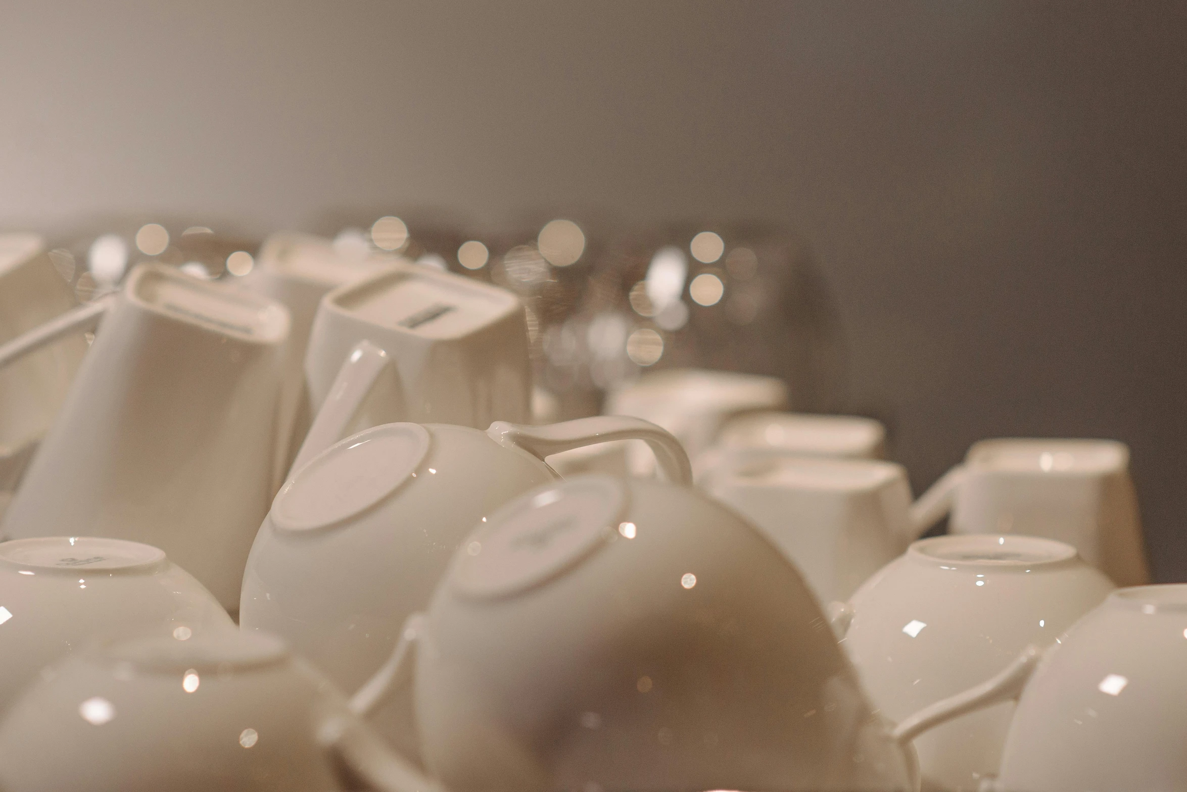 a bunch of white vases sitting on top of a table, inspired by Sarah Lucas, unsplash, process art, teapots, volumetric lighting 4k, sparkling, bottom body close up