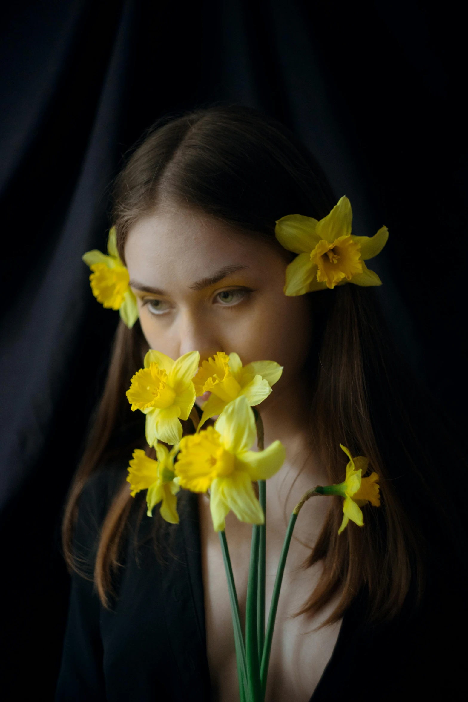 a woman holding a bunch of yellow flowers in front of her face, an album cover, by irakli nadar, daffodils, dramatic lowkey studio lighting, alessio albi, mary jane ansell