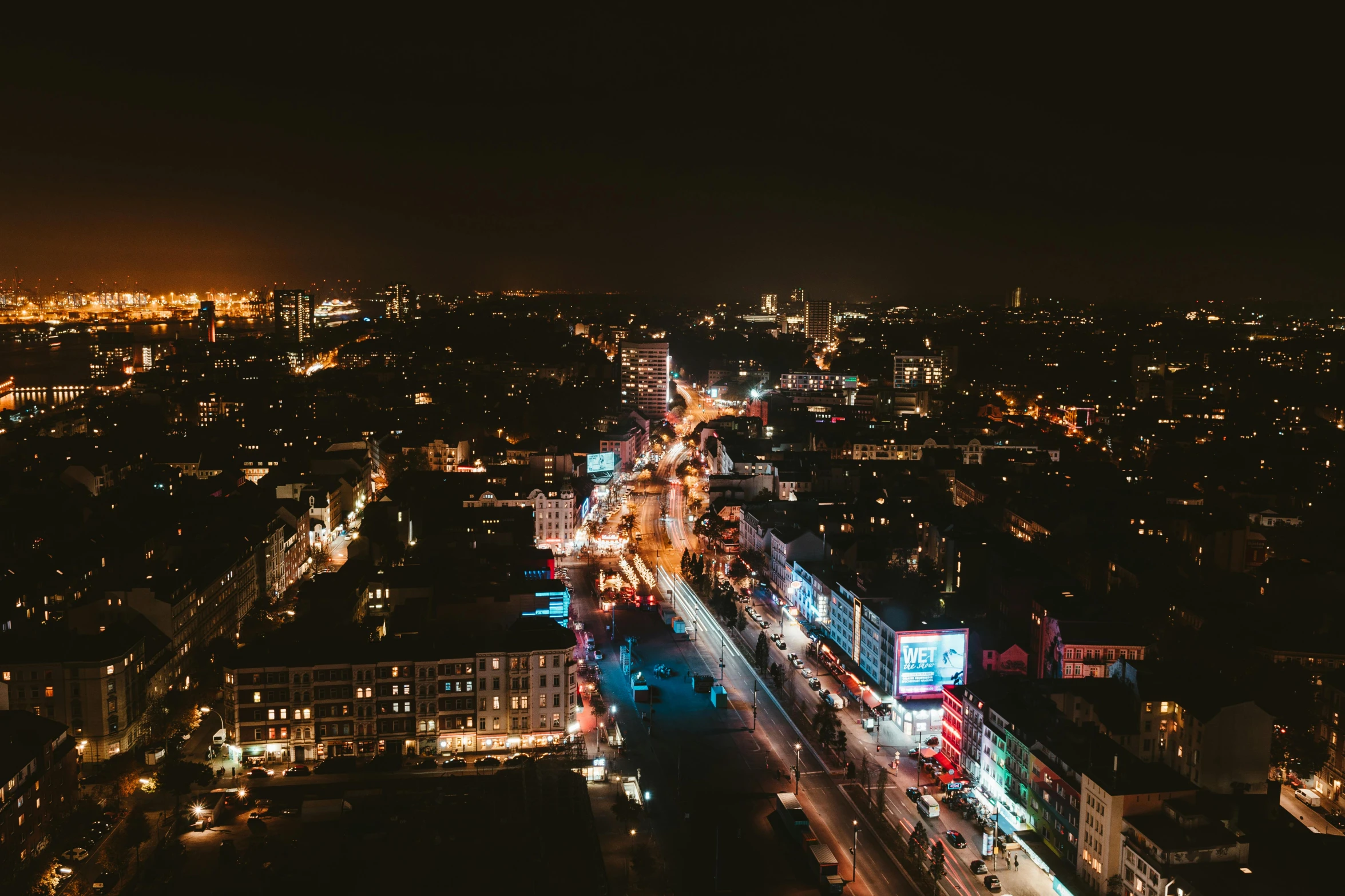 an aerial view of a city at night, by Niko Henrichon, pexels contest winner, happening, kreuzberg, nightlife, view from the side, jovana rikalo