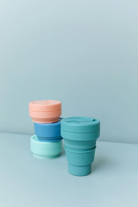 a couple of cups sitting on top of a table, product image, sherbert sky, silicone skin, stacks