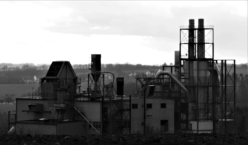 a black and white photo of a factory, by Kristian Zahrtmann, flickr, rusty metal towers, no foliage, skyline in back, colorless and silent