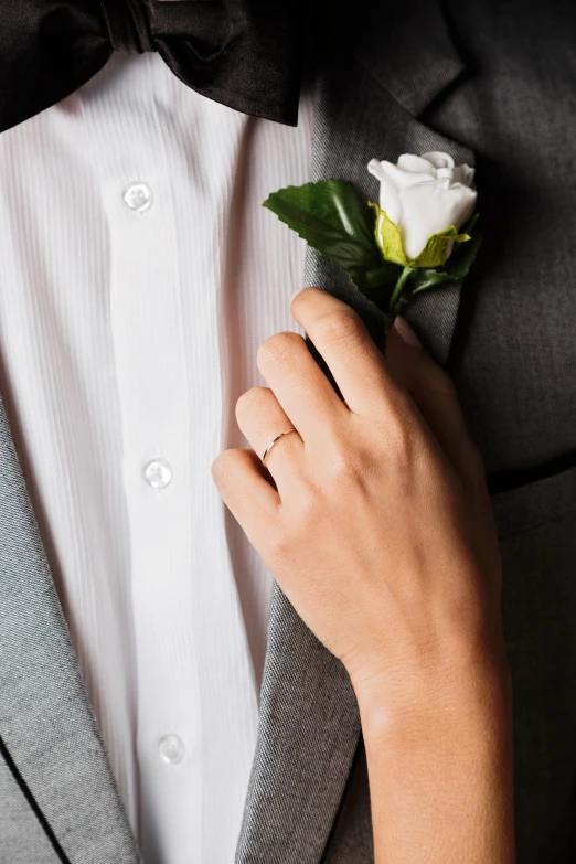 a close up of a person wearing a suit and tie, holding a rose, silver，ivory, wearing two metallic rings, design only