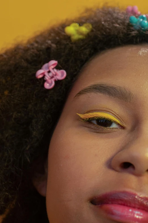 a close up of a person with a flower in her hair, an album cover, inspired by Carl Walter Liner, trending on pexels, yellow makeup, black teenage girl, eleven from stranger things, eye shadow