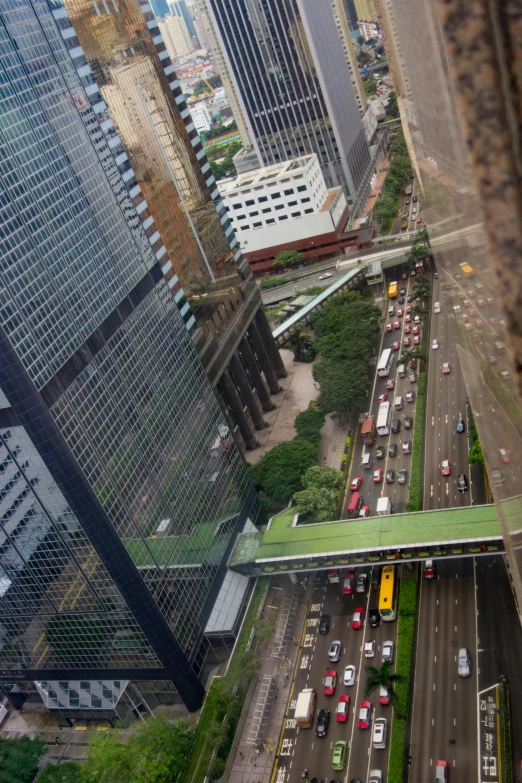 a city filled with lots of traffic next to tall buildings, a picture, reddit, happening, skybridges, the place is just really small, looking sideway, shot on nicon camera