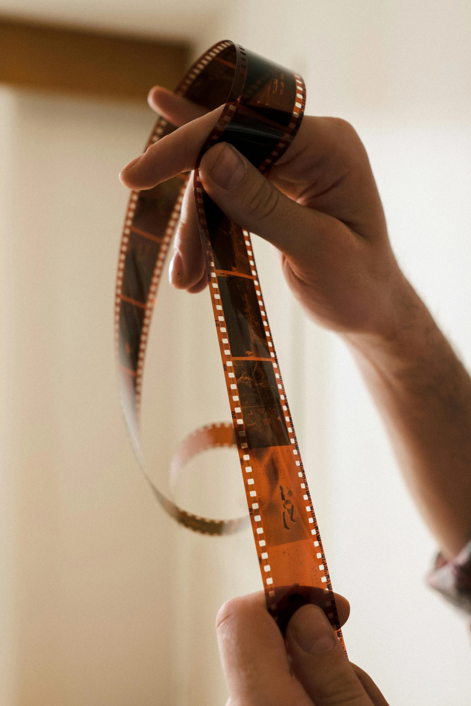 a close up of a person holding a film strip, colour photograph, cinematográfica, **cinematic, ribbons