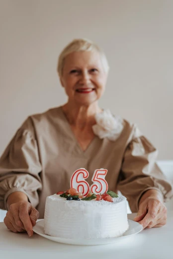 a woman sitting at a table with a cake in front of her, pexels contest winner, he is about 6 0 years old, 2 5 6 x 2 5 6 pixels, celebration, :6