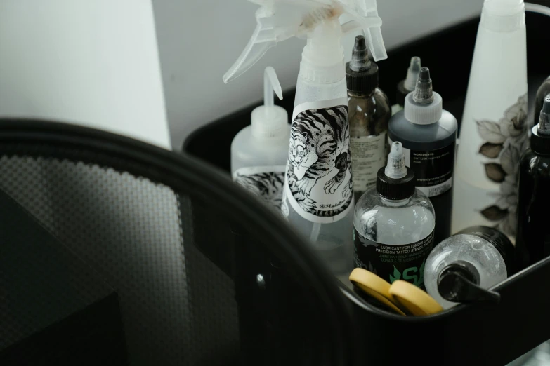 a close up of a table with a lot of items on it, an airbrush painting, pexels contest winner, black and grey tattoo style, skincare, bottles, spray